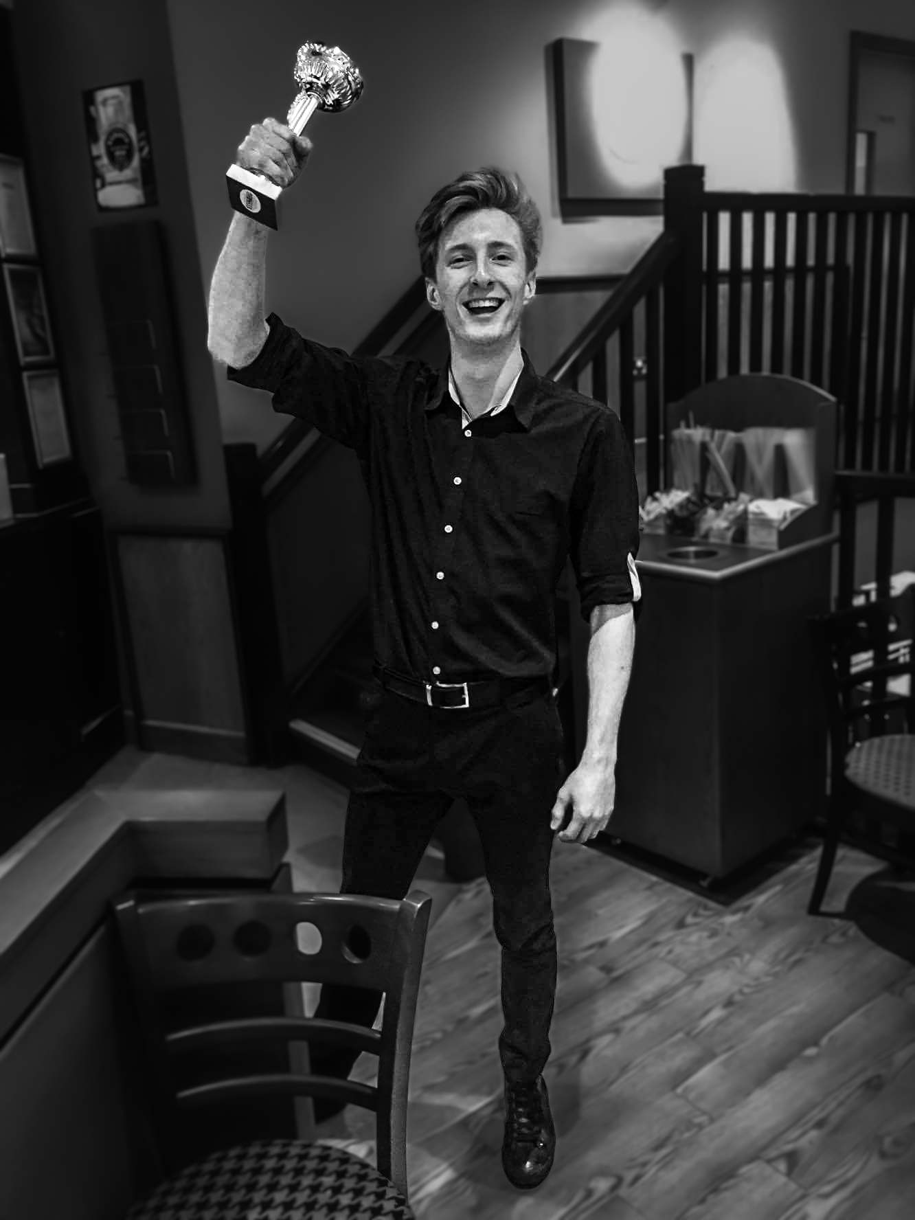 Adam holding an employee of the month trophy in his first coffee job